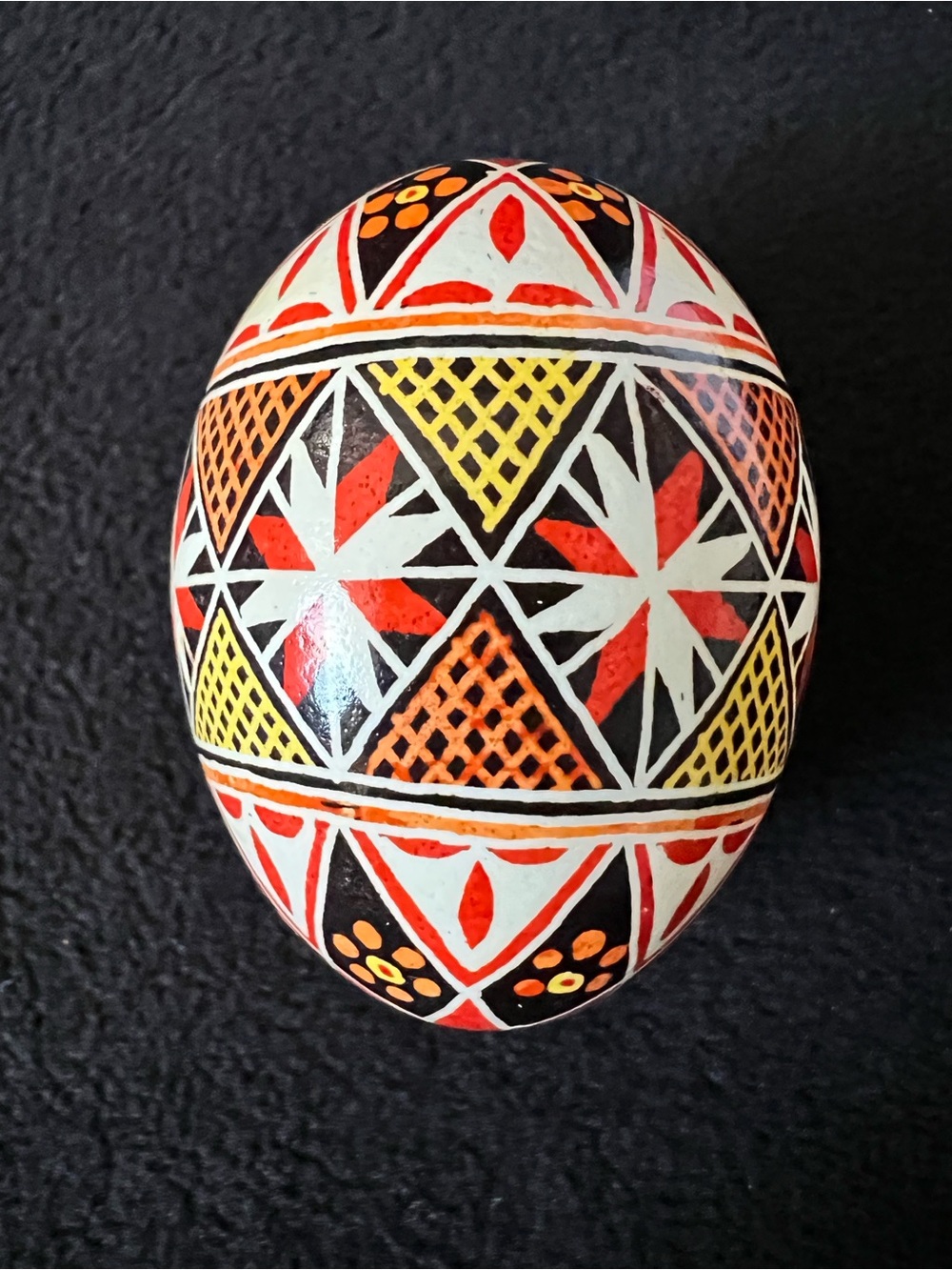 Hand-Painted Decorative Egg with Red, Yellow, Black Geometric Design